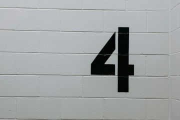 black arrow sign on white brick wall